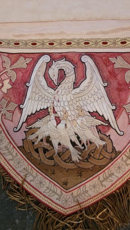 Man sieht einen Ausschnitt aus der Verzierung der roten Kasel