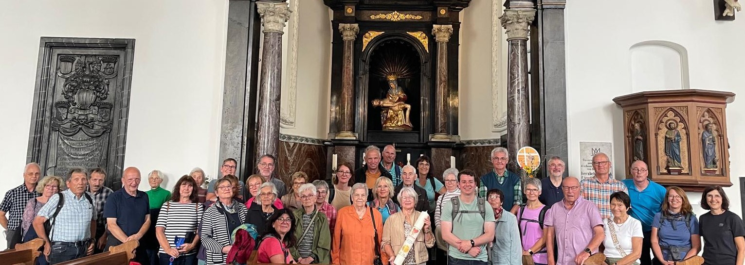 Man sieht eine Gruppe Menschen im Altarraum der Wallfahrtskirche Bornhofen stehen