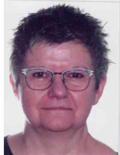 Man sieht das Proträt einer Frau mit schwarzen Haaren und einer Brille