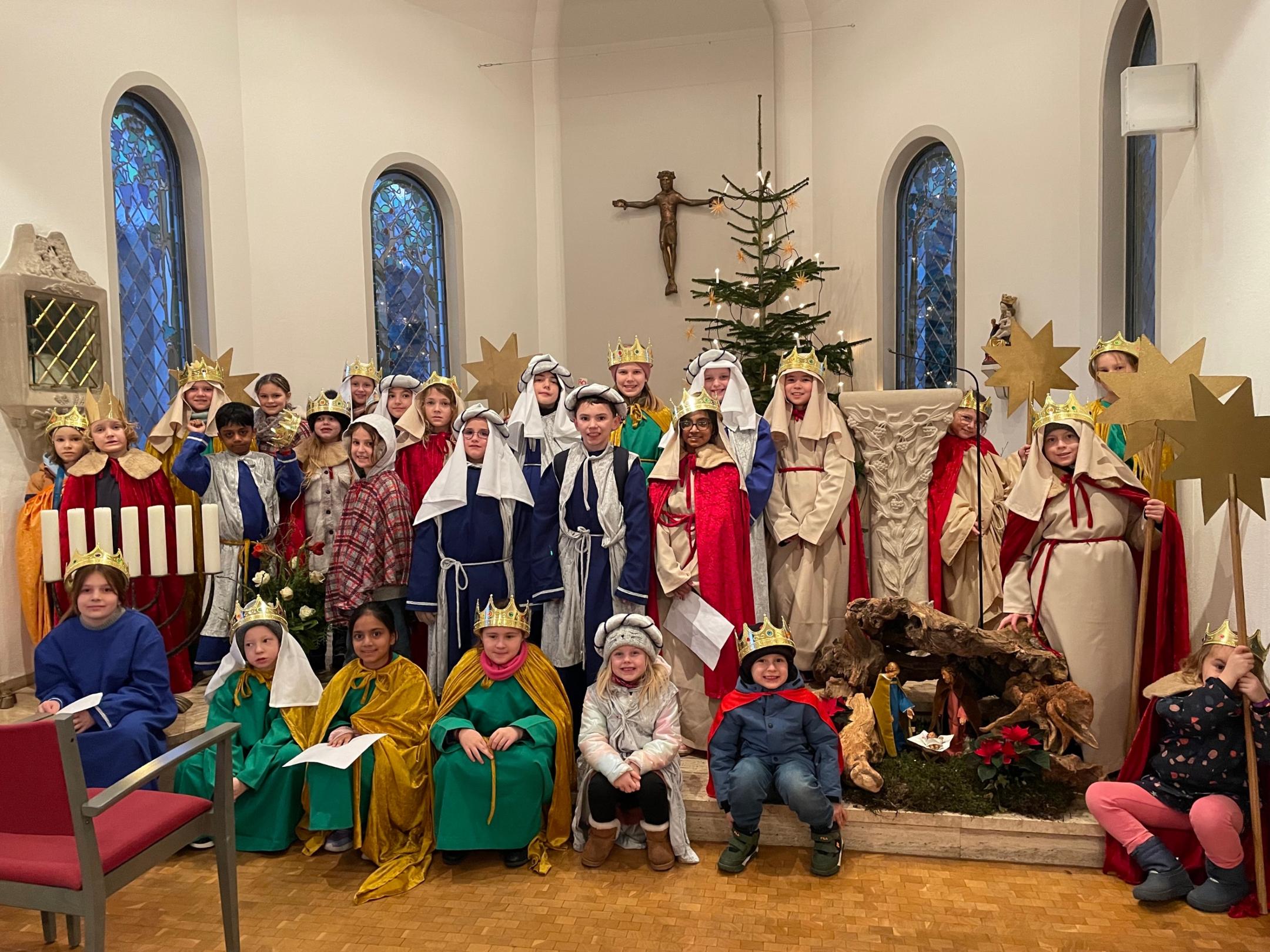 Sie Münstermaifelder Sternsinger stehen im Altarraum der Kapelle im Seniorenzentrum, manche als Könige verkleidet