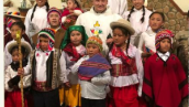 Man sieht Kooperator Lisowski im Messgewand, umringt von Kindern aus Bolivien in ortsüblicher, bunter Tracht