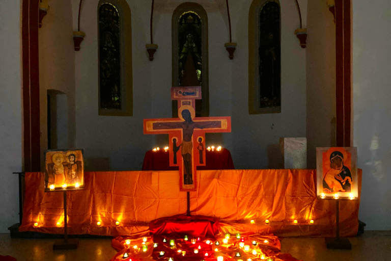 Man sieht den mit Kerzen und Tüchern geschmückten Altarraum der abgedunkelten Josefskapelle, davor Ikonen-Kreuze