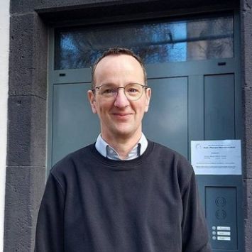 Das Bild zeigt Pfarrer kern vor der Pfarrhaustür in Münstermaifeld (c) Pfarrei Maifeld, Privat Das Bild zeigt Pfarrer kern vor der Pfarrhaustür in Münstermaifeld
