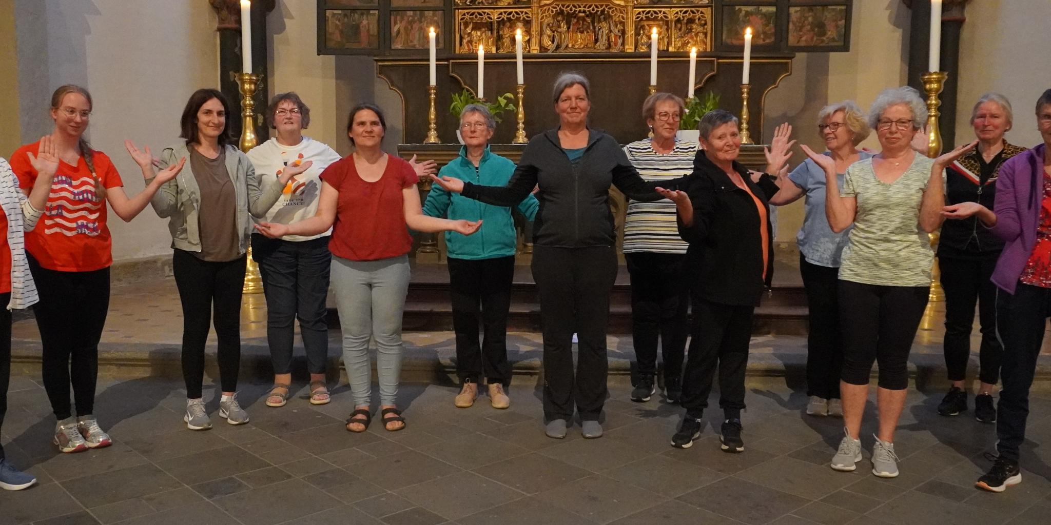 Man sieht Frauen im Sportdress vor einem Altar stehen, die Hände wie zum Gebet geöffnet (c) Privat Man sieht Frauen im Sportdress vor einem Altar stehen, die Hände wie zum Gebet geöffnet