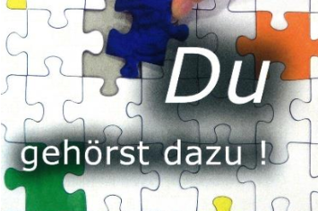 Man sieht ein schwarz-weiß Puzzle, in dem bunte Teile eingefügt sind mit der Aufsschrift: 'Du gehörst dazu!'
