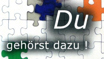 Man sieht ein schwarz-weiß Puzzle, in dem bunte Teile eingefügt sind mit der Aufsschrift: 'Du gehörst dazu!'
