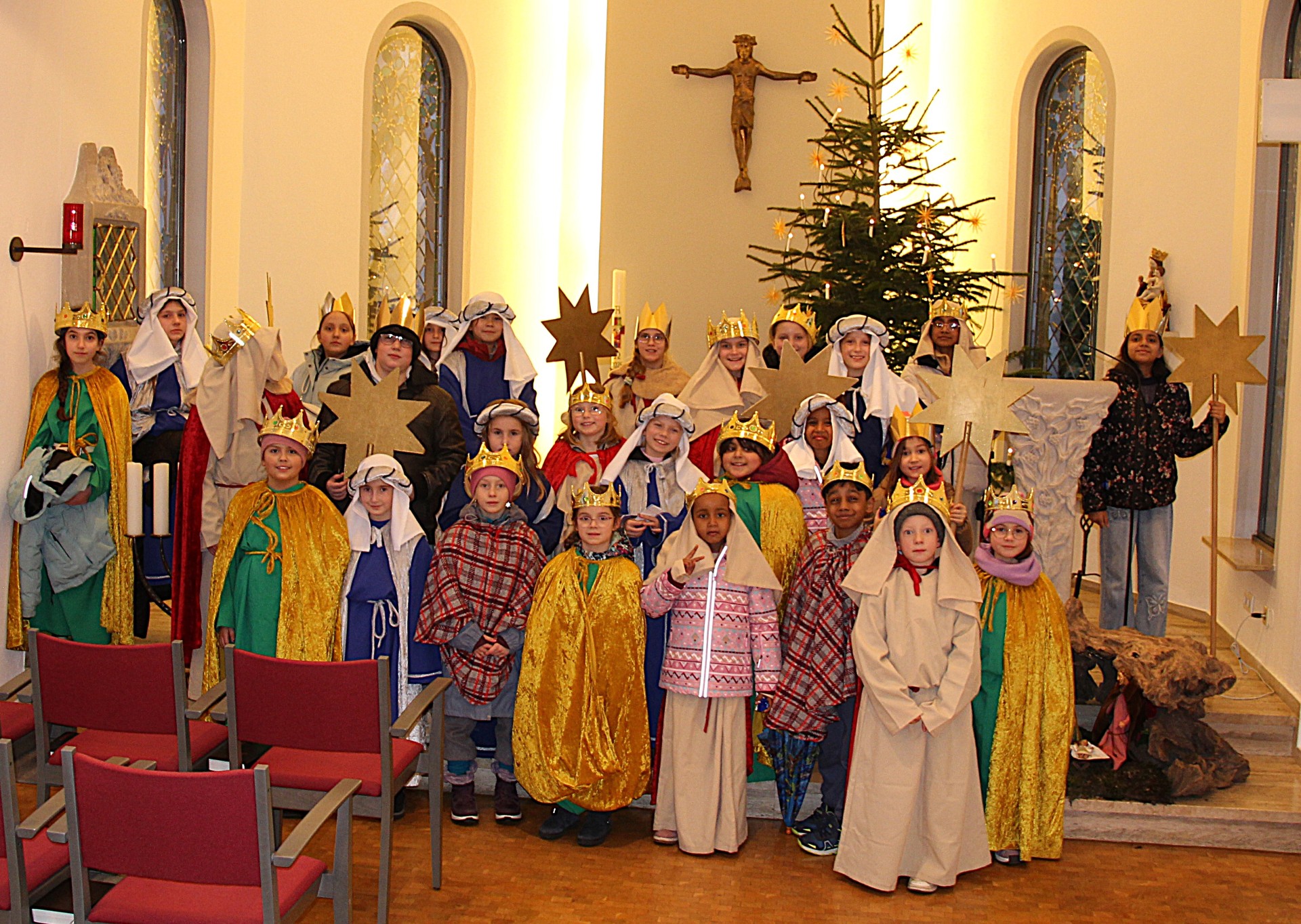 Man sieht Kinder als Könige/Sternsinger verkleidet im Altarraum der Kapelle St. Josef im Seniorenzentrum Münstermaifeld stehend