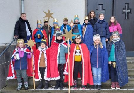 Man sieht eine Gruppe Kinder, teilweise als Könige verkleidet mit Stern und eine Betreuerin