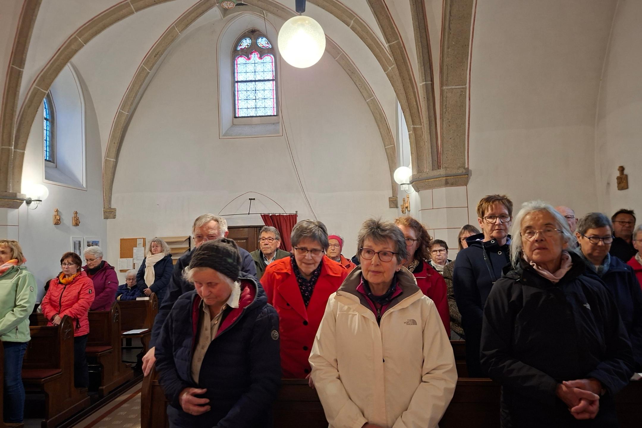 Man sieht Menschen, die sich in einer Kirche versammelt haben