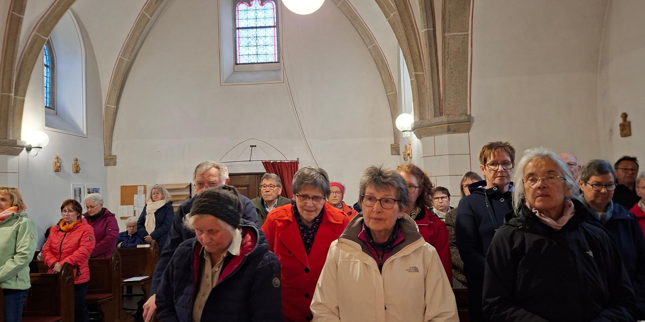 Man sieht Menschen, die sich in einer Kirche versammelt haben