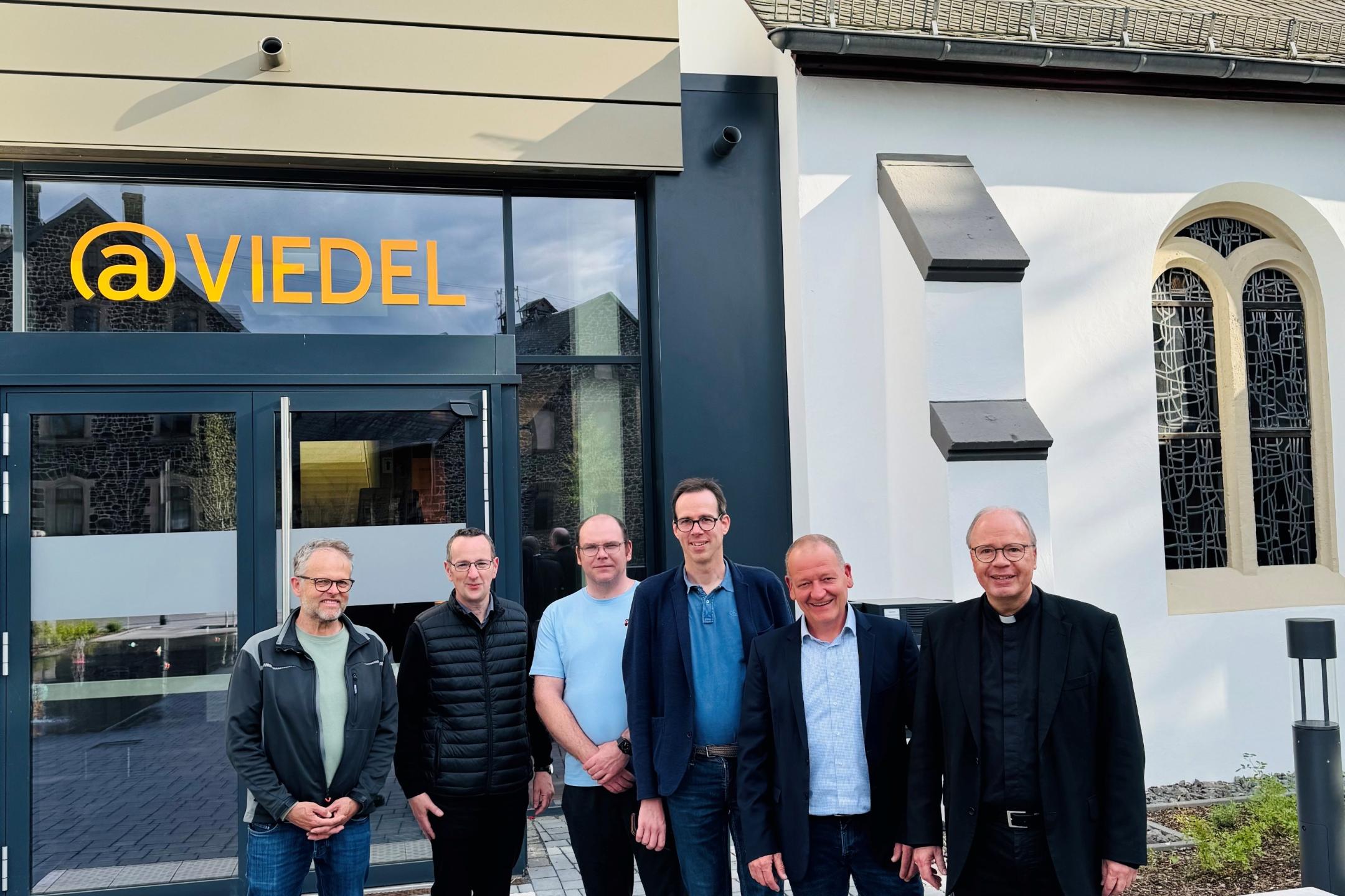 Zu sehen ist der Trierer Bischof, der Stadtbürgermeister von Polch, Pfarrer Kern, Rolf Seul und den Manager vor dem @Viedel-Gebäude