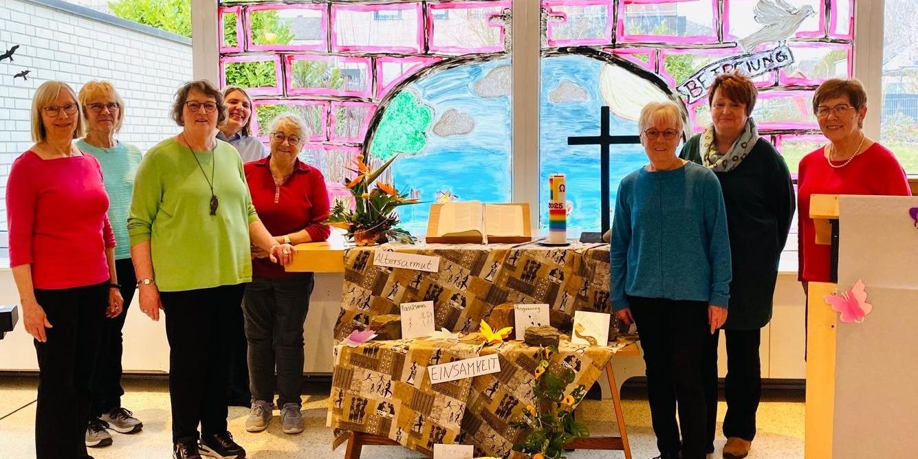 Man sieht in der Mitte einen Altar mit einer afrikanisch anmutenden Decke und Schlagworten geschmückt, mit Buch in der MitteKreuz rechts und (c) kfd Münstermaifeld Man sieht in der Mitte einen Altar mit einer afrikanisch anmutenden Decke und Schlagworten geschmückt, mit Buch in der MitteKreuz rechts und