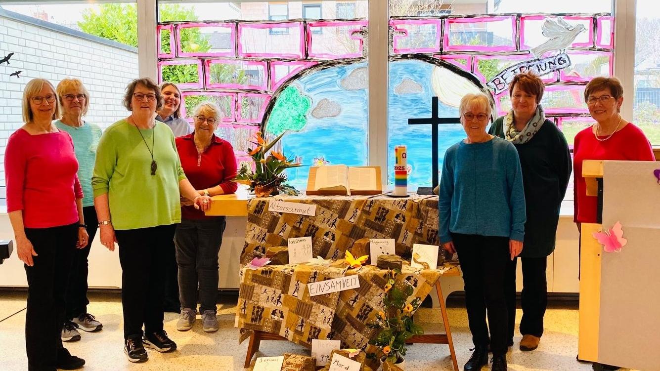 Man sieht in der Mitte einen Altar mit einer afrikanisch anmutenden Decke und Schlagworten geschmückt, mit Buch in  der MitteKreuz rechts und