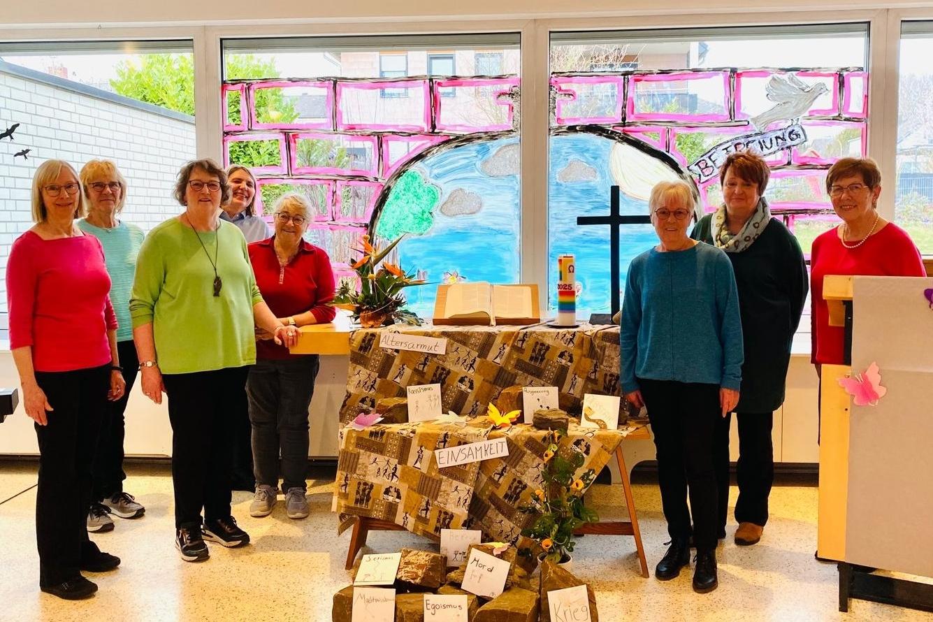Man sieht in der Mitte einen Altar mit einer afrikanisch anmutenden Decke und Schlagworten geschmückt, mit Buch in  der MitteKreuz rechts und