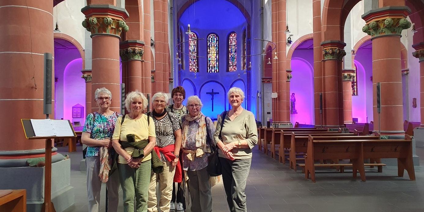 Man sieht eine Gruppe von älteren Frauen in einem Kirchenraum stehen