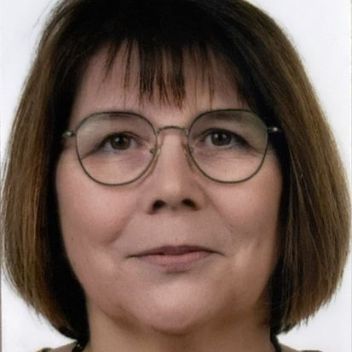 Man sieht das Porträt einer Frau mit brünettem Haar und Brille
